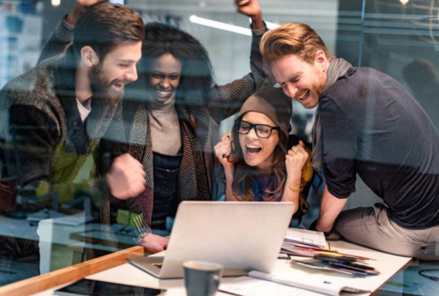 A group of people looking at a computer Description automatically generated